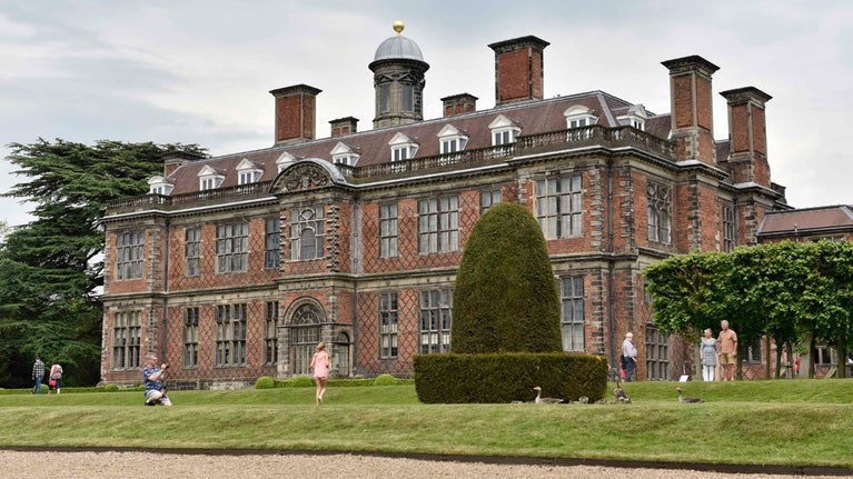 Visitors in the garden in front of the hall at Sudbury Hall and the National Trust Museum of Childhood, Derbyshire